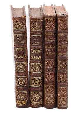 quatre vieux livres sont alignés sur une surface blanche