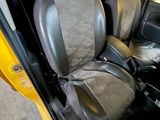 a yellow truck with two seats in the back of it
