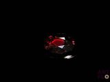 un gros plan sur un diamant rouge dans l'obscurité
