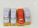 four toy cars are lined up in a row next to each other