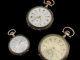 trois montres de poche anciennes sur fond noir, avec un fond noir