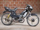 a black motorcycle parked in front of a brick wall