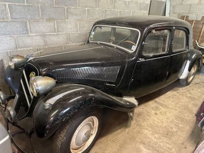 une voiture noire garée dans un garage à côté d'autres voitures