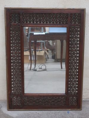 a mirror that is sitting on the ground in front of a wall