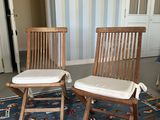 two wooden chairs sitting on a blue rug in a room