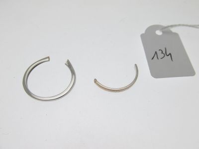 deux paires de boucles d'oreilles créoles en argent posées sur un fond blanc