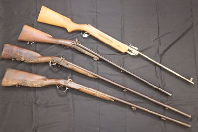 five different types of guns are lined up on a black cloth