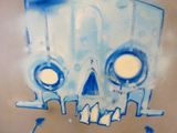 a blue and white painting of a skull on the side of a building