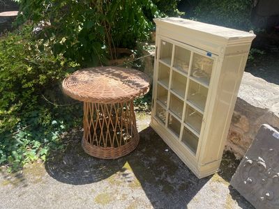 une petite table avec une porte vitrée, à côté d'un petit meuble