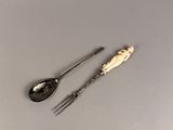 two spoons and a fork sitting on a table