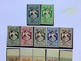 plusieurs timbres différents, de couleurs et de motifs variés, sur une feuille de papier