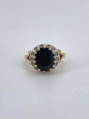 a gold ring with a blue stone surrounded by white diamonds