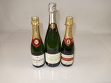 three bottles of champagne sitting on a counter top next to each other