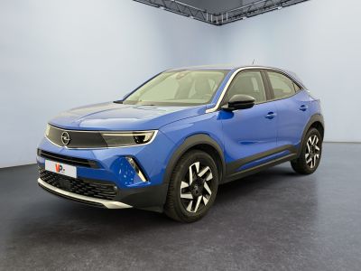 a blue car is parked in a large room with a white wall