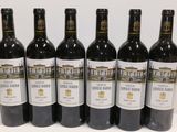 six bottles of wine are lined up in a row on a table