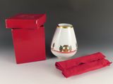 une boîte rouge avec un vase blanc et une serviette rouge