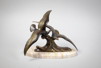 sculpture of two birds flying over a tree branch on a marble base