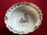 a small white bowl with a flower design on it