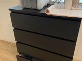 a black chest of drawers with a printer on top of it