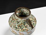 a small vase with a handle on a white table