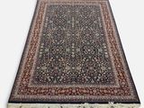 un tapis noir et rouge à franges sur fond blanc