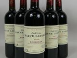 six bouteilles de vin sont alignées sur une table