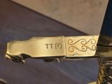 a close up of a gold sword with a name engraved on it