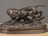 a bronze statue of a dog chasing a cat on a rock