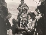 black and white photograph of a group of people sitting under a tree