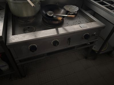 une cuisinière sur laquelle sont posées une casserole et une poêle, dans une cuisine