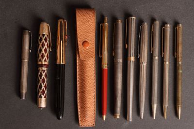 Plusieurs stylos et un stylo sont alignés sur une table