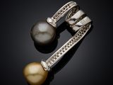 a pair of pearl and diamond earrings on a black surface
