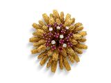 une image représentant une broche en or et rubis sur fond blanc