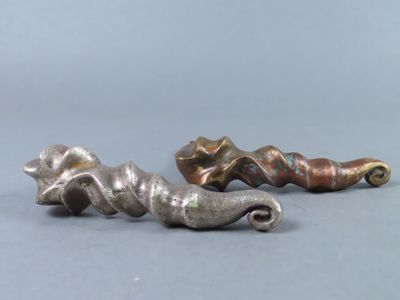 two silver and gold colored metal objects on a gray surface