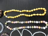 a lot of beads and bracelets that are on the table