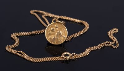 a close up of a gold coin on a chain on a black surface
