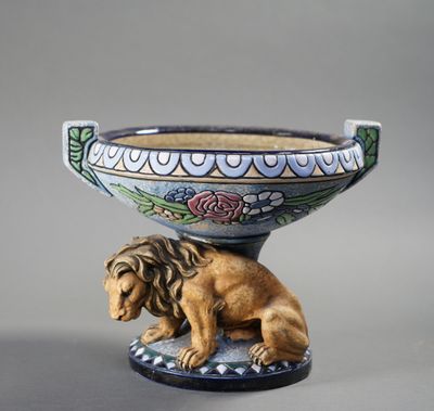 une statue représentant un lion assis sur un bol