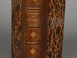 an old book with a brown cover sitting on top of a table