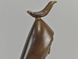 bronze statue of a woman with a bird on her head