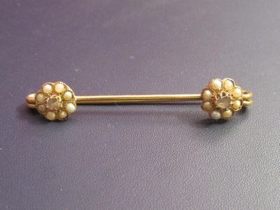 an image of a gold nose piercing with pearls on it