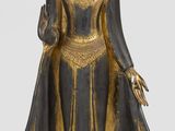 une image représentant une statue d'une femme vêtue d'une tenue noire et dorée