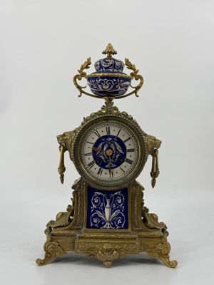 une horloge posée sur un socle, surmontée d'un bol