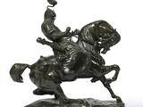 bronze statue of a man on a horse with a bird on its back