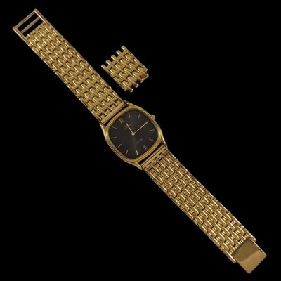 un gros plan d'une montre-bracelet en or au cadran noir