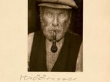 une vieille photo d'un homme avec une pipe à la bouche
