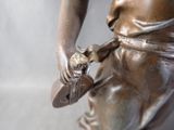 a bronze statue of a woman holding a flower