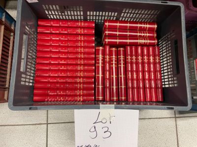 many red books in a plastic basket on the floor