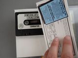 a person holding a ticket and a cassette in their hand