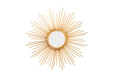 un gros plan d'un miroir doré à rayons de soleil accroché à un mur blanc