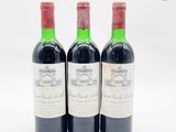 trois bouteilles de vin rouge posées l'une à côté de l'autre sur une surface blanche